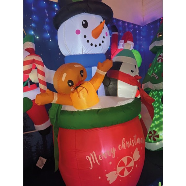 Muñeco de nieve hinchable en taza con pingüino y galleta de jengibre
